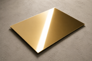 Plaque rectangulaire en aluminium miroir doré brillant posée sur un fond texturé clair